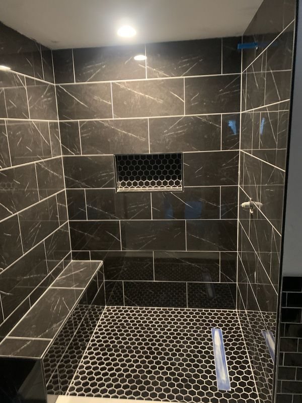 Black marble shower, hex floor & bench