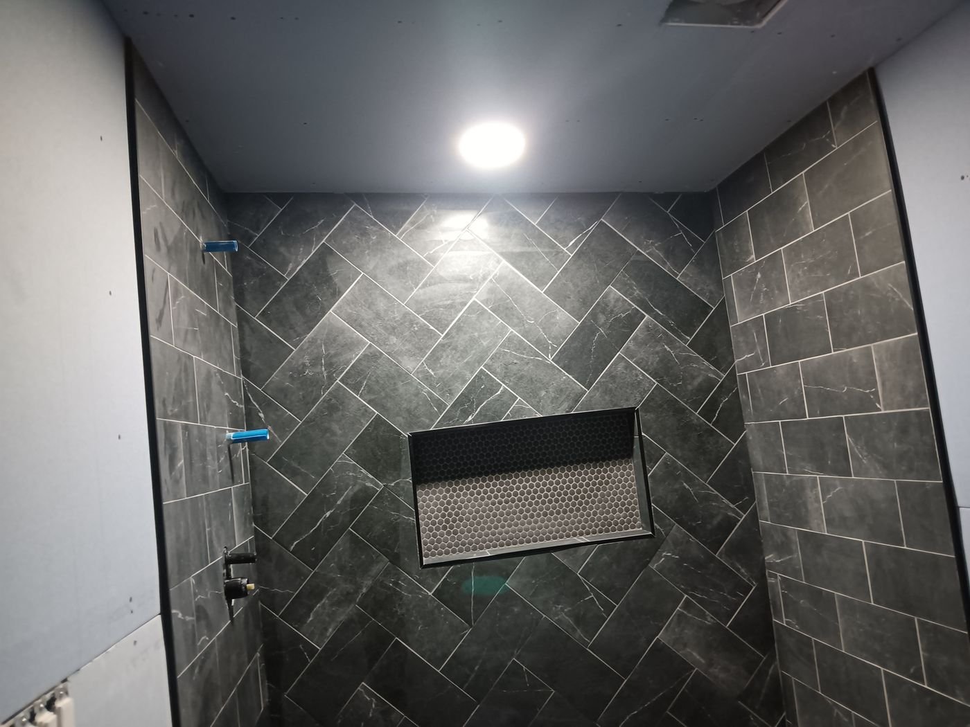 Charcoal herringbone shower with niche