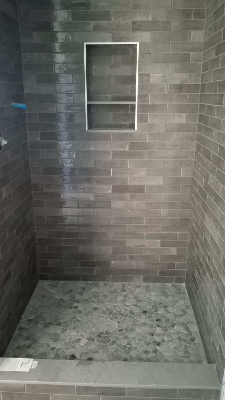 Gray subway shower, pebble floor