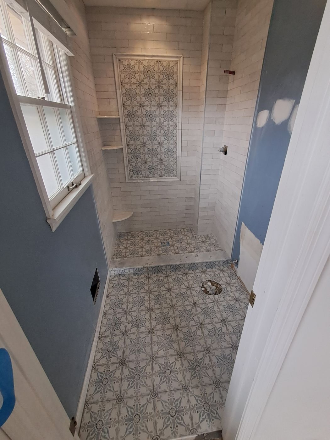 Walk-in shower with patterned floor