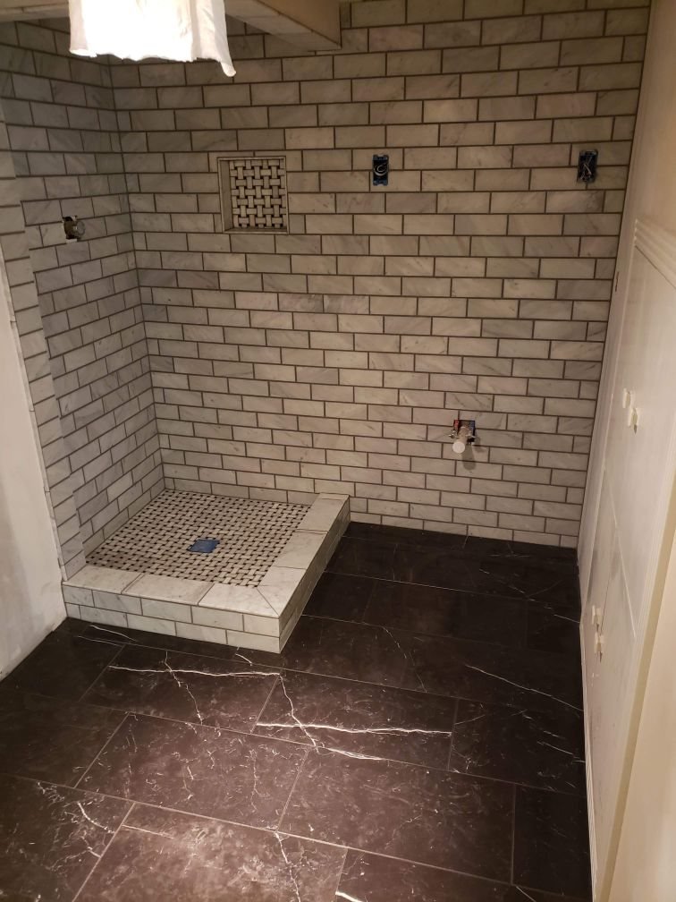 Subway tile shower, dark marble floor