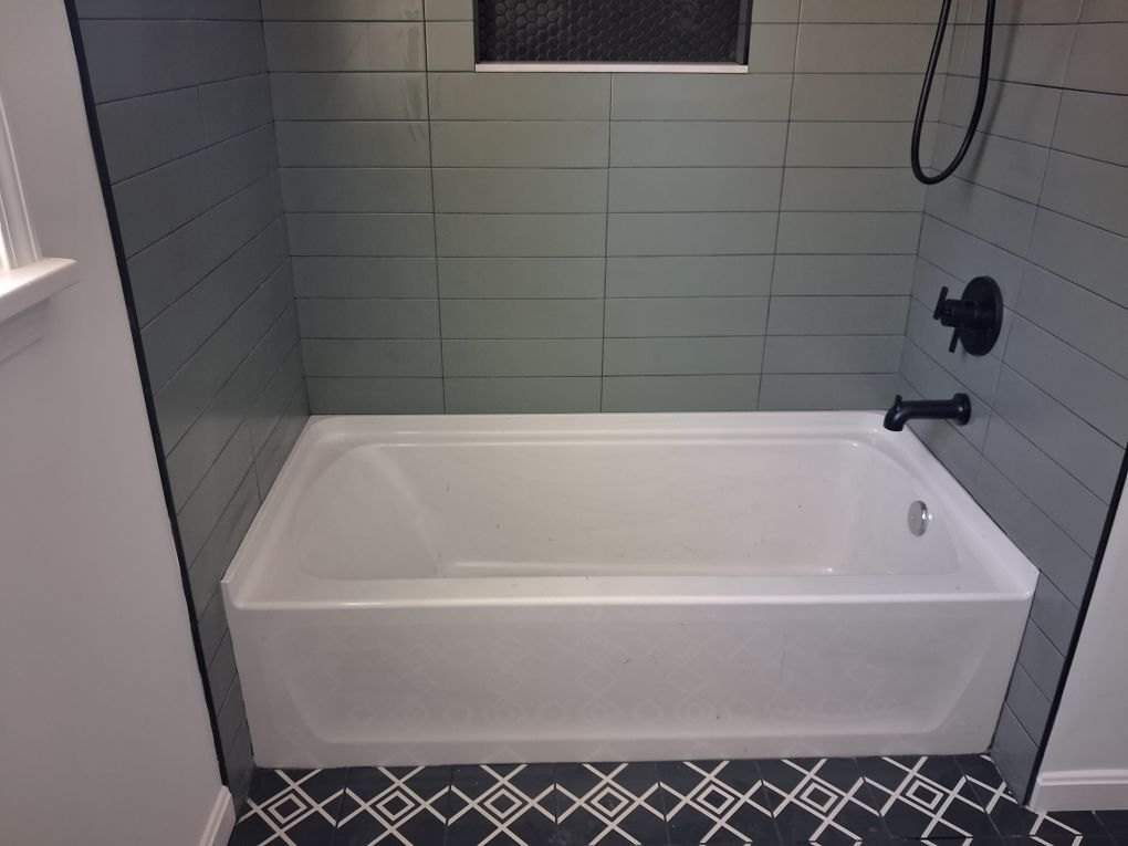 Green subway tub surround, patterned floor